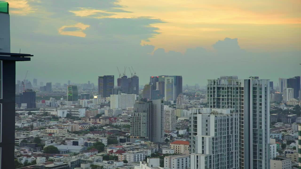 Edifícios urbanos na capital de Bangkok durante os céus alaranjados do entardecer