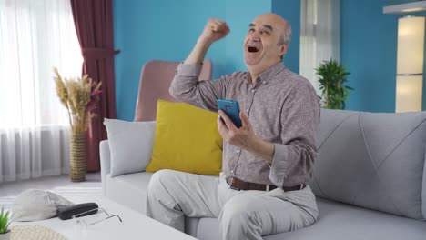 the old man looking at the phone rejoices with happiness.