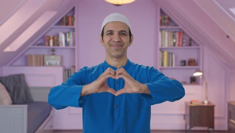 happy muslim man smiling and showing heart sign