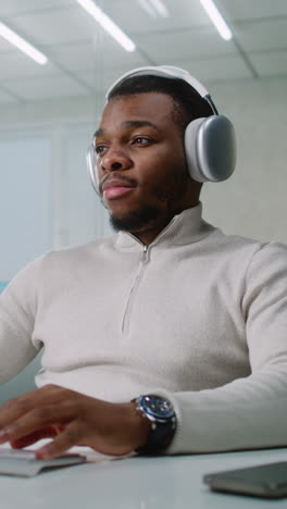 man working at computer with headphones