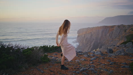 carefree woman running evening hill. cheerful happy girl spinning looking camera