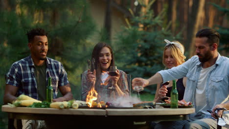 Hombre-Concentrado-Vertiendo-Aceite-En-La-Comida-Al-Aire-Libre.-Amigos-Teniendo-Miedo-Del-Fuego