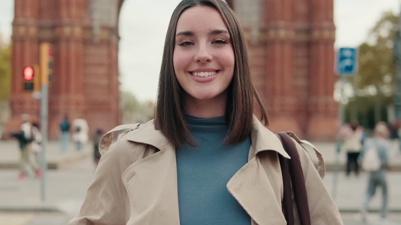Smiling Young Woman in Trench Coat Standing in City Street