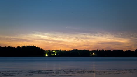 Timelapse-of-a-band-of-orange-colored-clouds-floating-over-the-blue-surface-of-the-lake