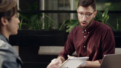 a young man and woman using a digital tablet