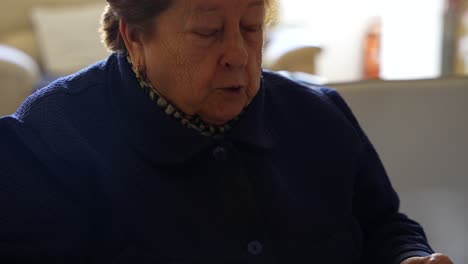 old woman chewing while eating an orange, medium shot in 4k