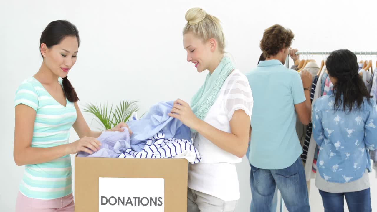 equipo de personas pasando por la caja de donación de ropa