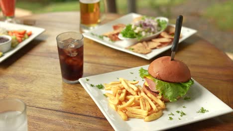 hamburguesa con papas fritas y refresco, afuera, junto con ceviche