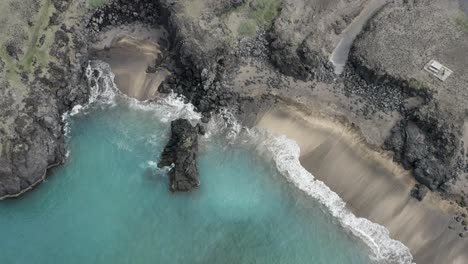 Antena-De-La-Famosa-Playa-Skardsvik-Con-Agua-Turquesa-Y-Acantilado-Rocoso-En-Islandia