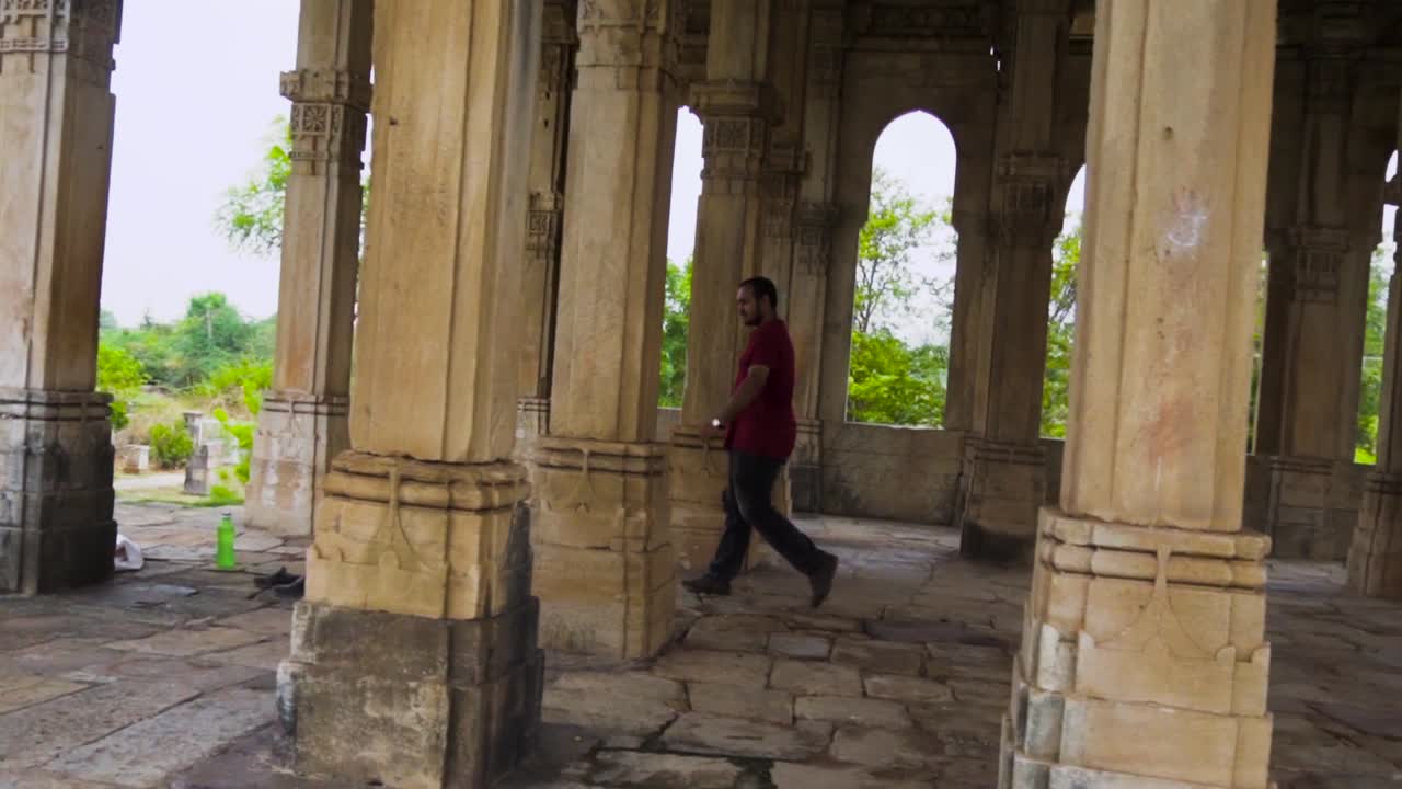 Uomo che esplora la Moschea di Kevada, una moschea a Champaner, stato del Gujarat.