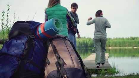 young travelers make halt and walking along little wooden moorage