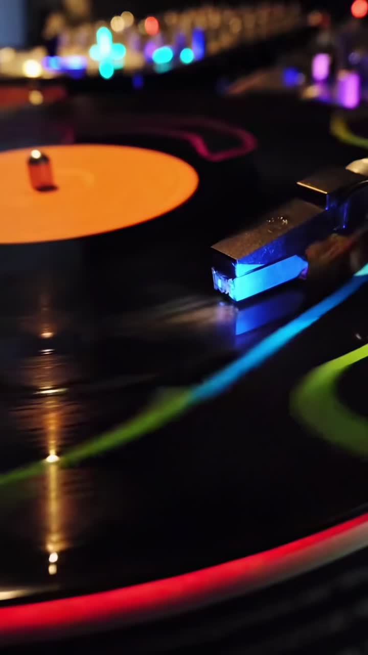 Video ravvicinato di un disco in vinile che gira con luci colorate, ripreso da un'angolazione bassa.