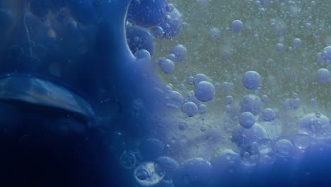 blue liquid background. macro shot of various air bubbles. slow mo.