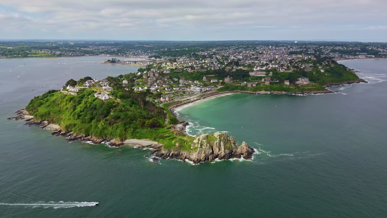 Backward drone movement from the coastal headland Pointe du Chateau with Trestrignel beach, Perros-Guirec, Brittany, France.