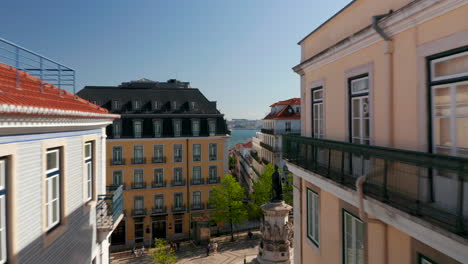 Cámara-De-Drones-Volando-En-El-Nivel-Del-Piso-Superior-Sobre-Calles-Estrechas-Hacia-La-Orilla-Del-Río.-Lisboa,-Capital-De-Portugal.