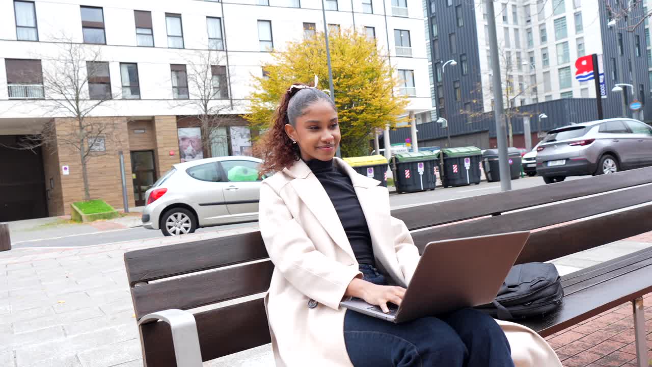 Woman working on laptop in city park