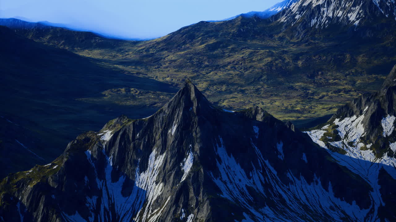 Majestic mountain peak rises above lush green valley landscape