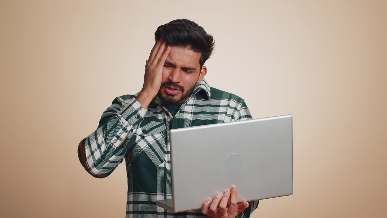 Indian man working on laptop loses becoming surprised by lottery results bad news fortune loss fail
