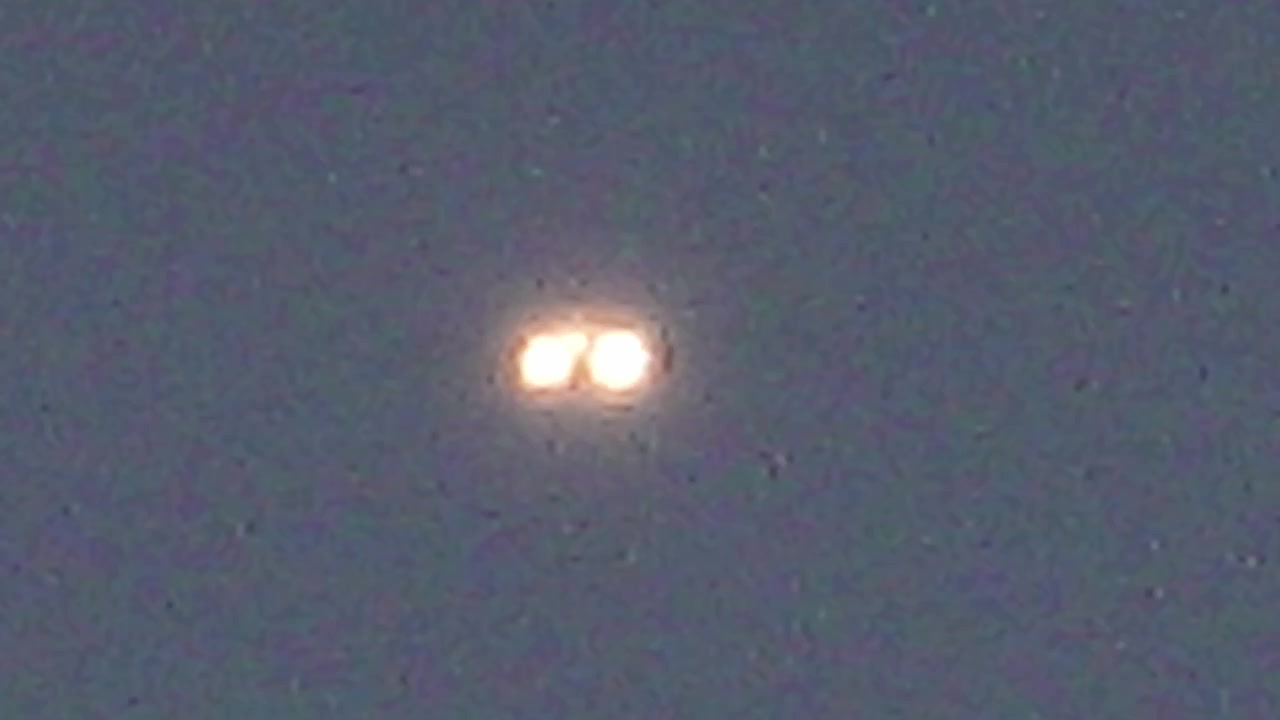 Unidentified flying object with glowing lights in dark sky