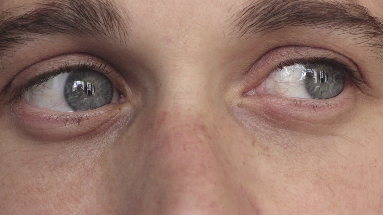 카메라를 바라보는 청년의 파란 눈의 클로즈업 아이리스에 대한 고민적인 반사