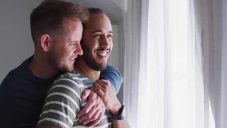 Multi-ethnic-gay-male-couple-embracing-and-smiling