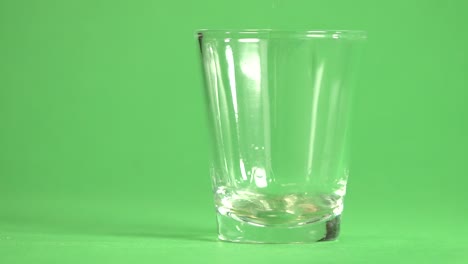 tequila vertido en un vaso sobre un fondo cromático