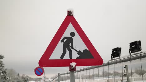 Traffic sign construction, on a winter day, with cloudy and foggy sky in the background