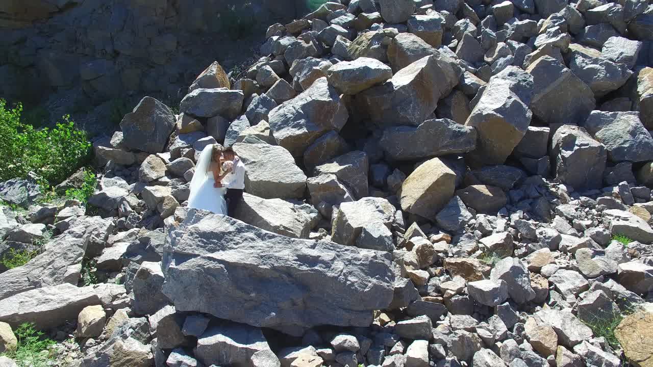 Beauty Bride With Groom. Aerial shot of a cheerful married couple standing and posing on the stones