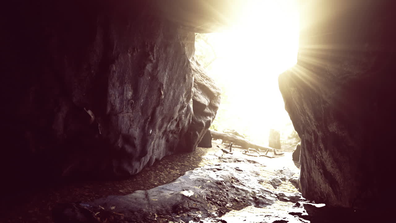 Sunlight streaming through a cave opening in a natural landscape
