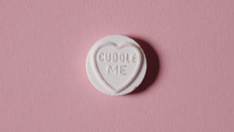 heart candy with cuddle me message on pink background