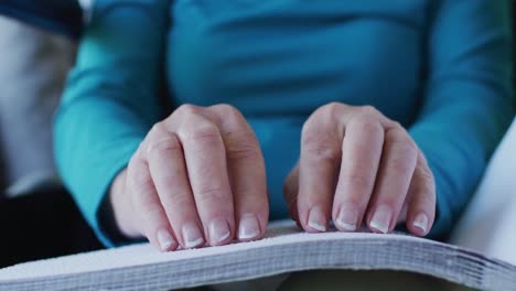 Mid-section-of-woman-reading-braille-book