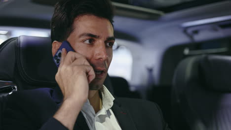 businessman talking on phone in a car