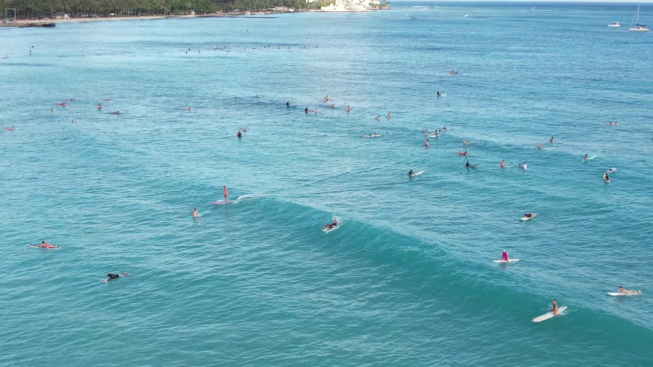 los surfistas atrapan olas en una popular ubicación de surf en una playa tropical