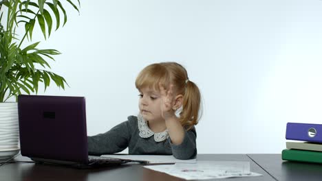 preschool child girl distance online learning at home. kid studying using digital laptop computer