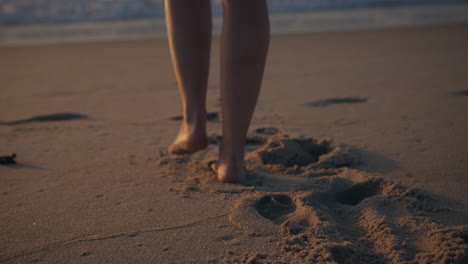 girl walking towards the sea golden hour sunset slow motion shot