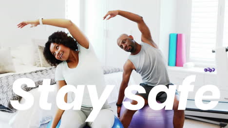 animation os stay safe text over man and woman exercising with swiss balls at home