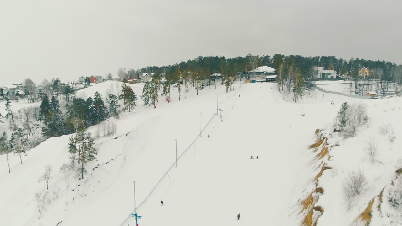 la gente sale con la fune fino alla cima della collina coperta di neve