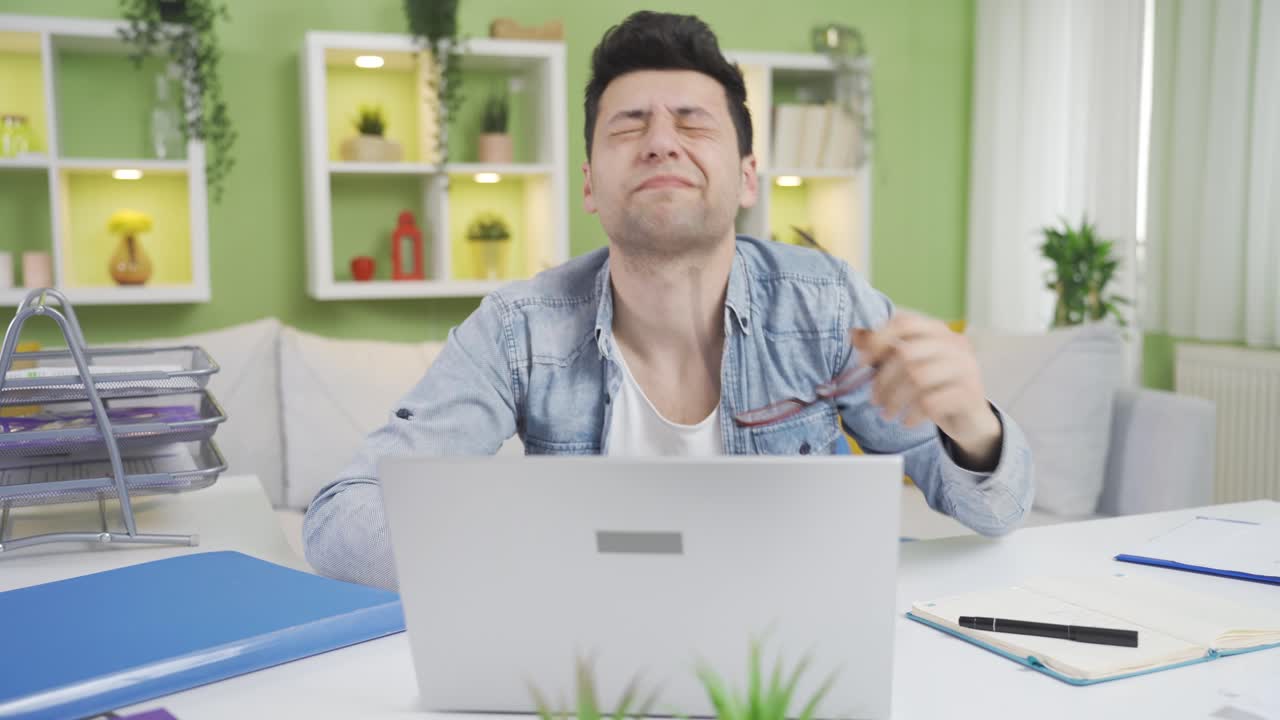 그의 어색한 홈 오피스 직원 안경을 착용하면서, 그는 그의 눈을 잡고 상처를 입습니다.