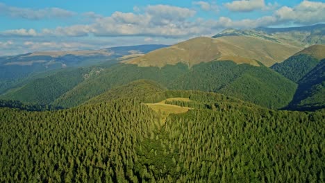 Aerial-drone-footage-view-of-Tarcului-Carpathian-mountains-with-a-beautiful-green-meadow-and-trees