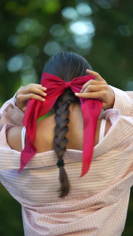 woman with a red bow in her braided hair