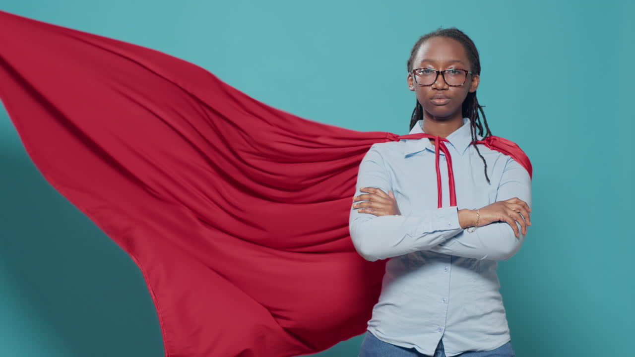 Portrait of female superhero wearing red cape costume