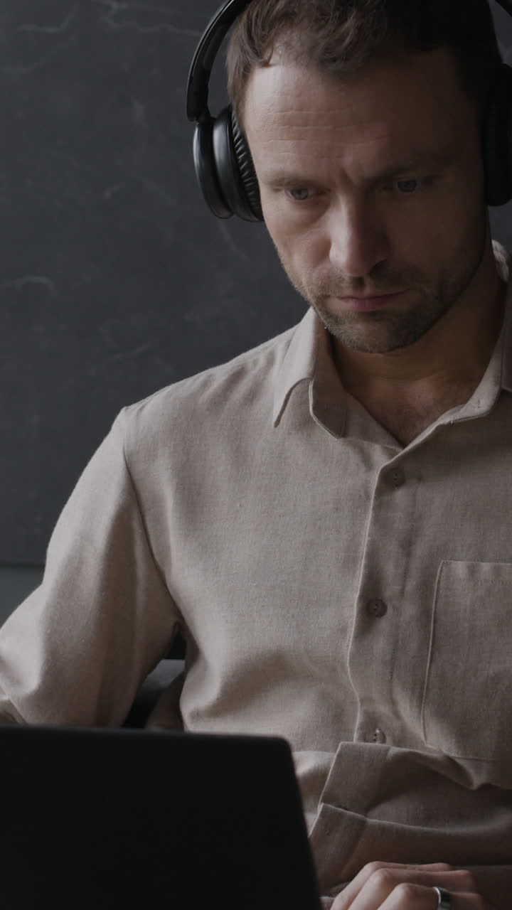 Uomo che lavora sul portatile con le cuffie