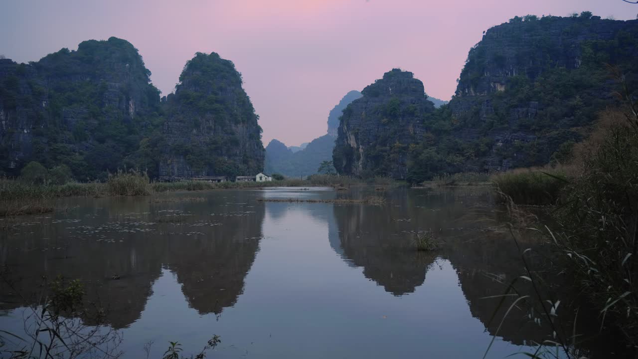 Reflective Ninh Binh Wetland Reserve With Limestone Karsts In Background Against Pink Cloudy Sky