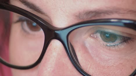 glasses close up, of a young woman concentrated in her work