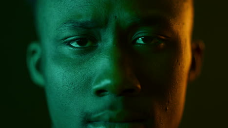 close-up portrait of a man with green and orange lighting