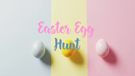 animation of easter egg hunt text over colourful easter eggs on blue, yellow and pink background