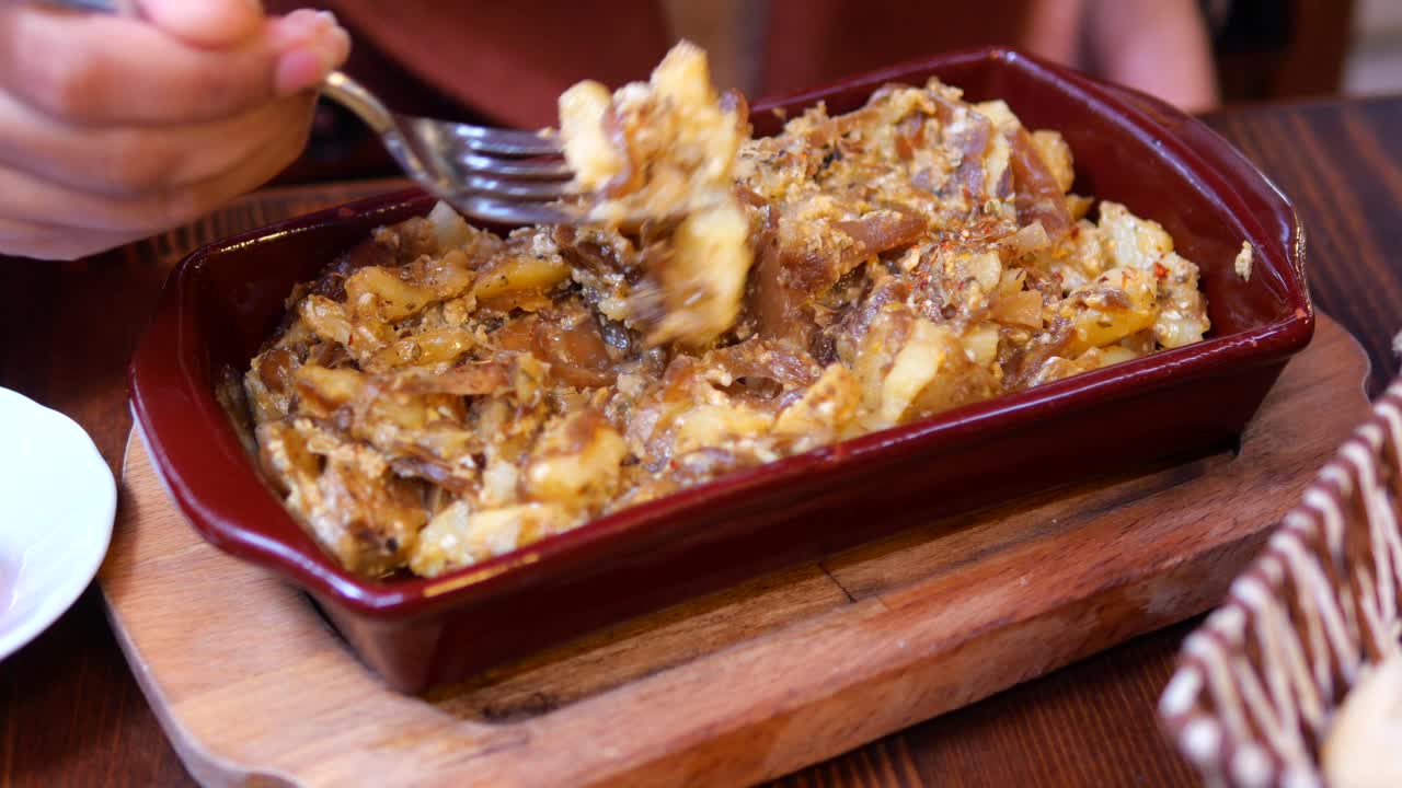 Person eating potatoes dish