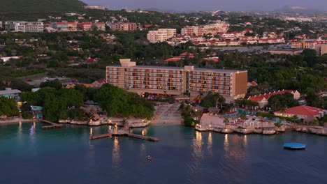 wide angle aerial orbit around exclusive hotel and private beach in caribbean at dusk