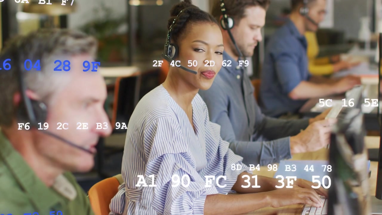 Support agent woman taking call, typing to resolve ticket, hex overlay moving over monitors
