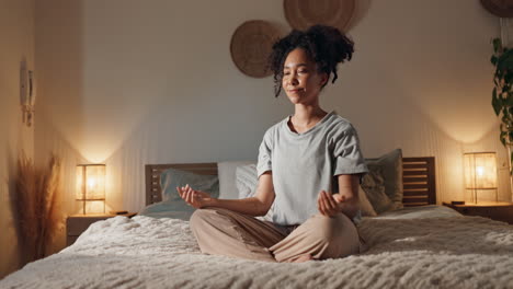 woman meditating in bed at night